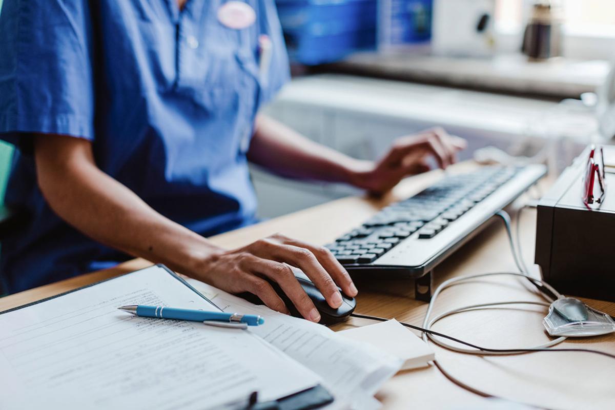 Health care professional working at a desktop computer